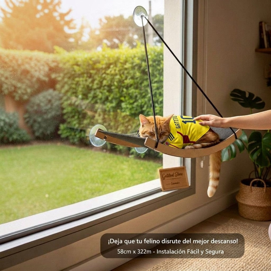 Gatitud Store cama hamaca grande para gatos de tela paño alto gramaje fijada a ventana con ventosas, gato naranja con camiseta amarilla durmiendo.