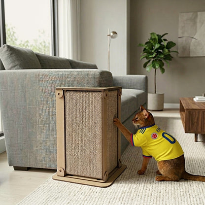 Gato con camiseta de Colombia usando rascador esquinero de madera MDF y sisal natural de Gatitud Store en sala moderna.